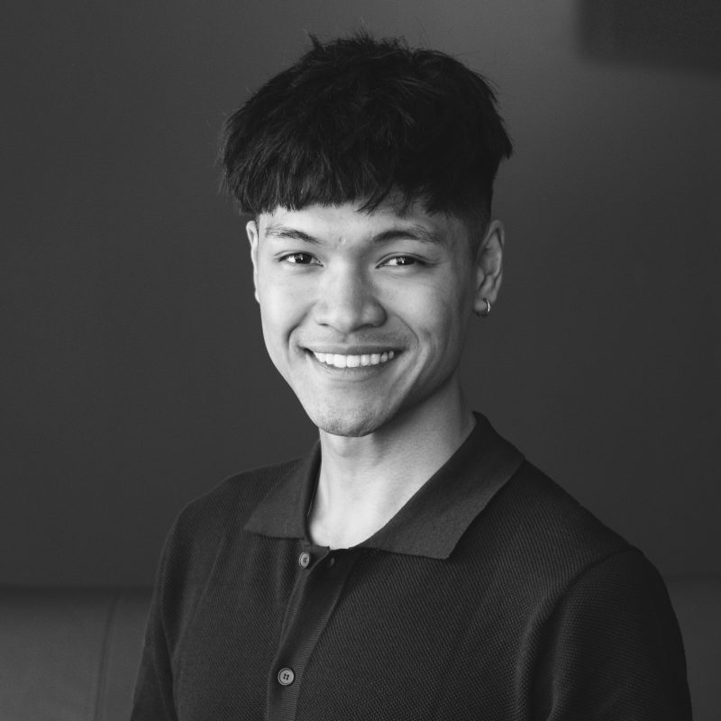 A black and white photo of a young man named Robert Haidl smiling.