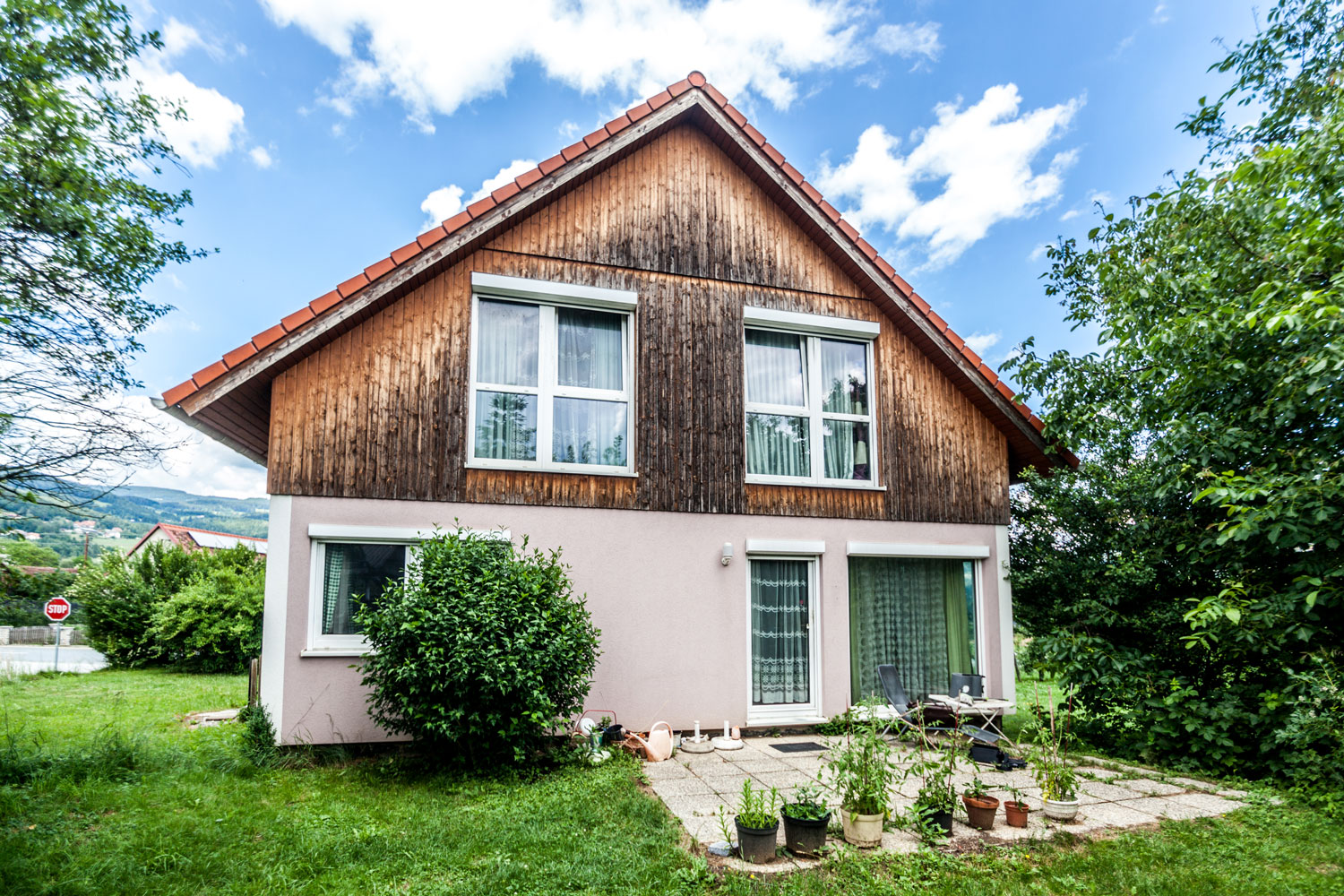 A Gersin Real Estate property featuring a wooden siding and a green lawn.