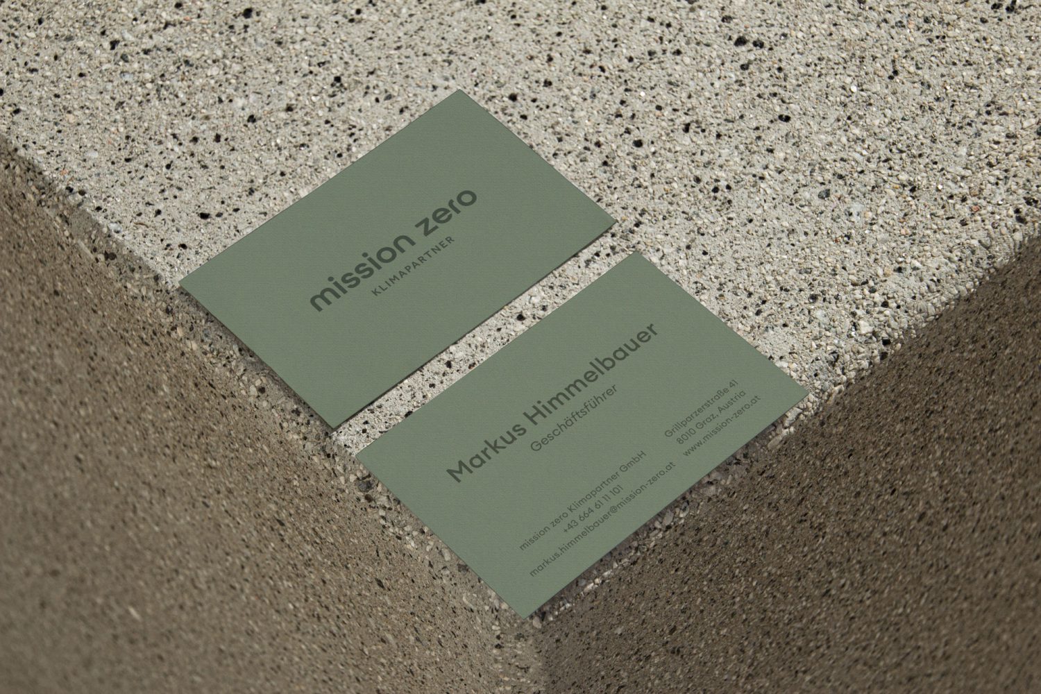 A business card promoting Mission Zero sitting on top of a concrete wall.