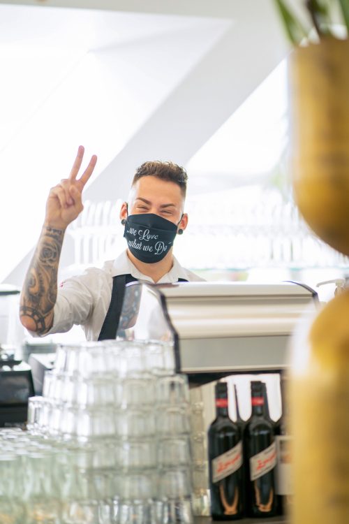 A bartender at Freiblick Tagescafé wearing a mask.