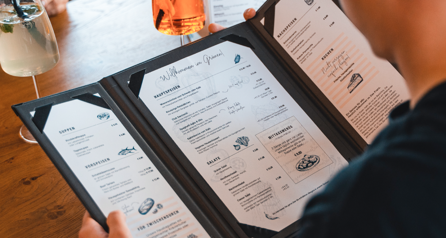 A person holding a menu at a restaurant.