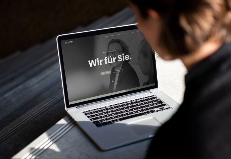 Eine Frau schaut auf einen Laptop mit der PMT-Website darauf.