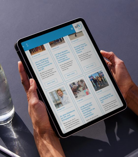 A woman is using an iPad to read a newspaper digitally.