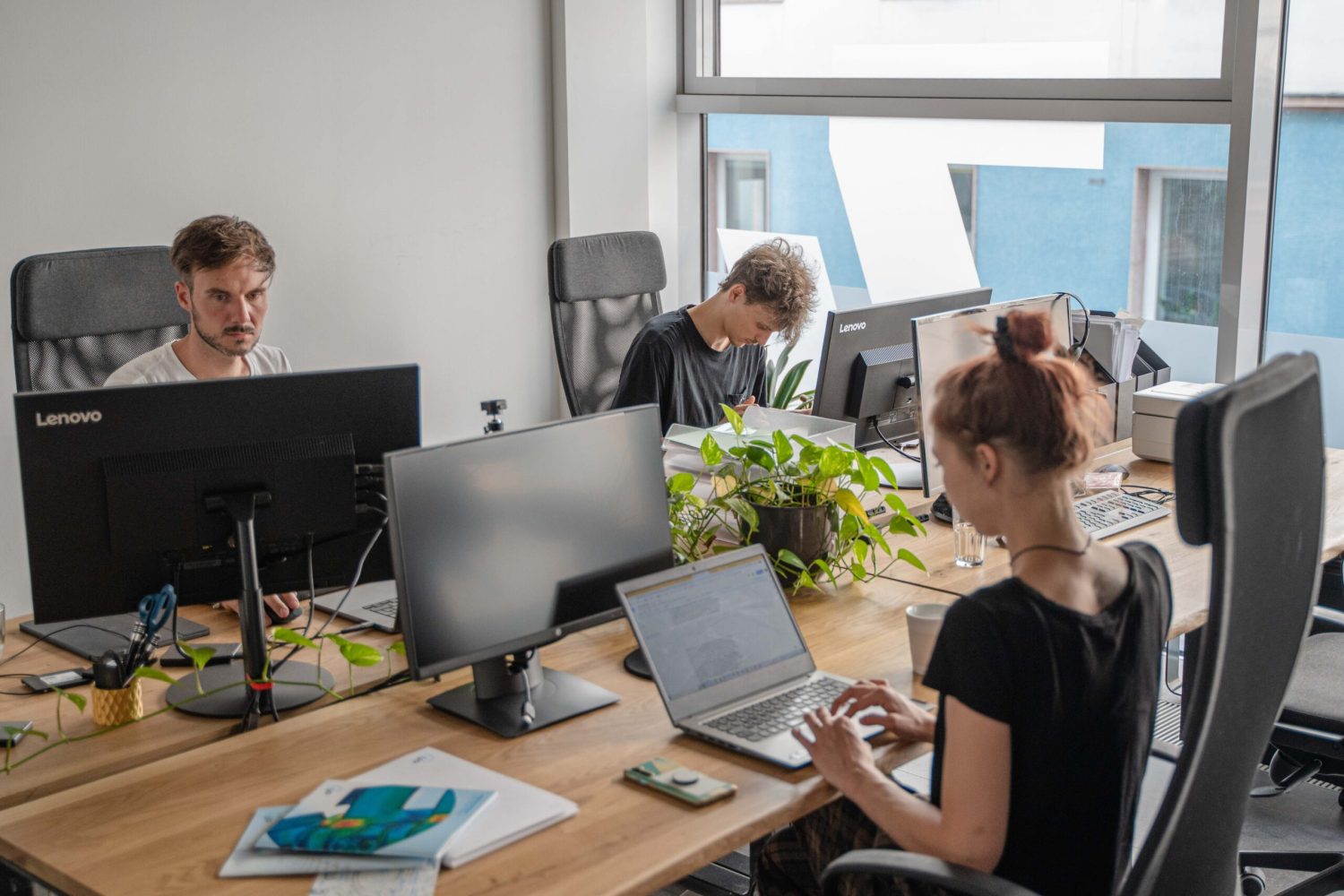 A group of people working at a desk in an office.