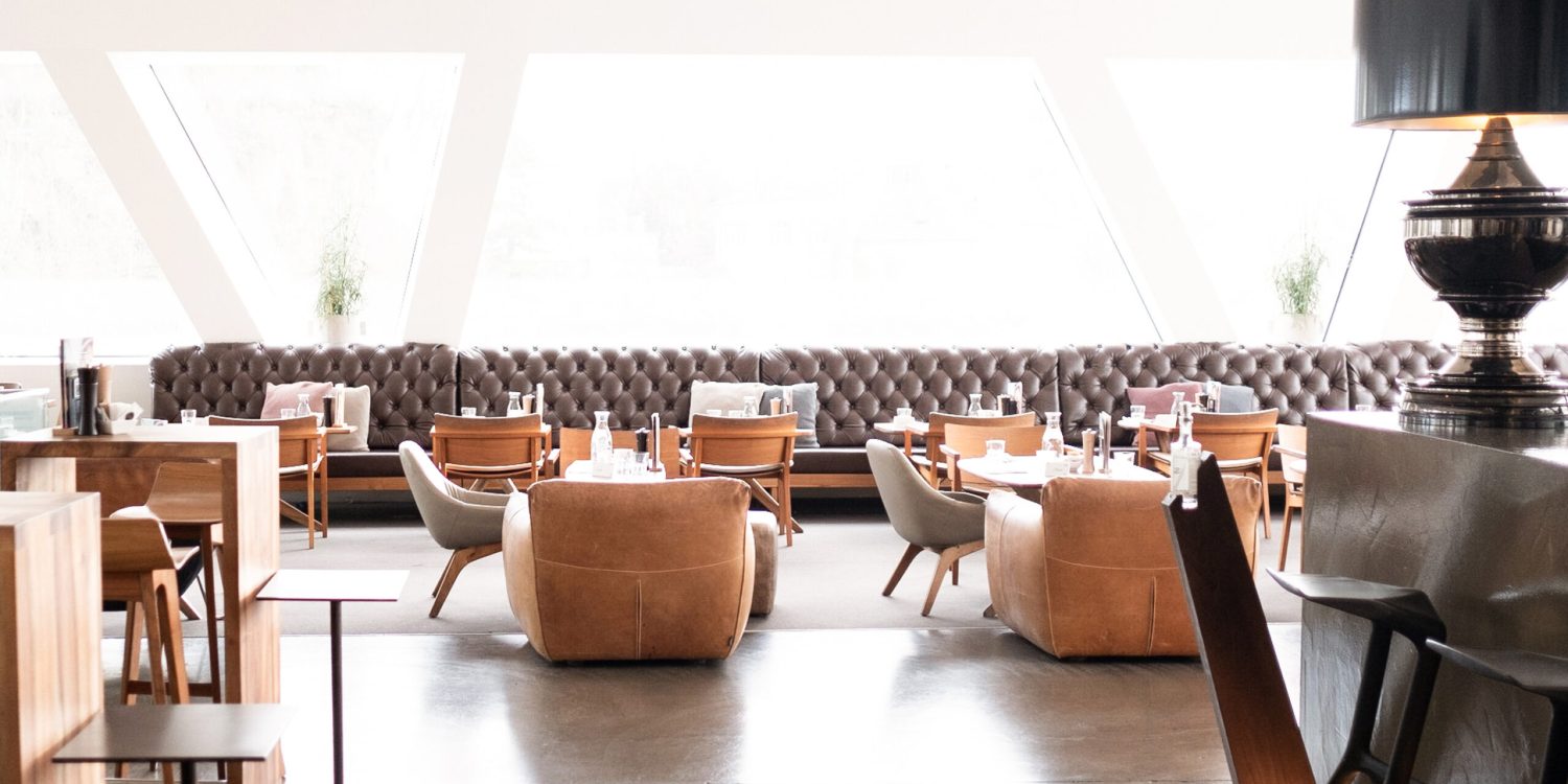 The interior of a Freiblick Tagescafé with wooden tables and chairs.