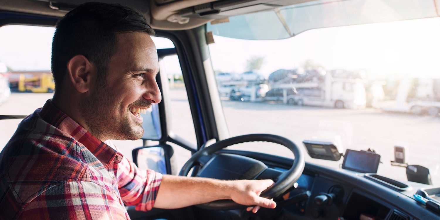 A man sitting in the driver's seat of an Intellic truck.